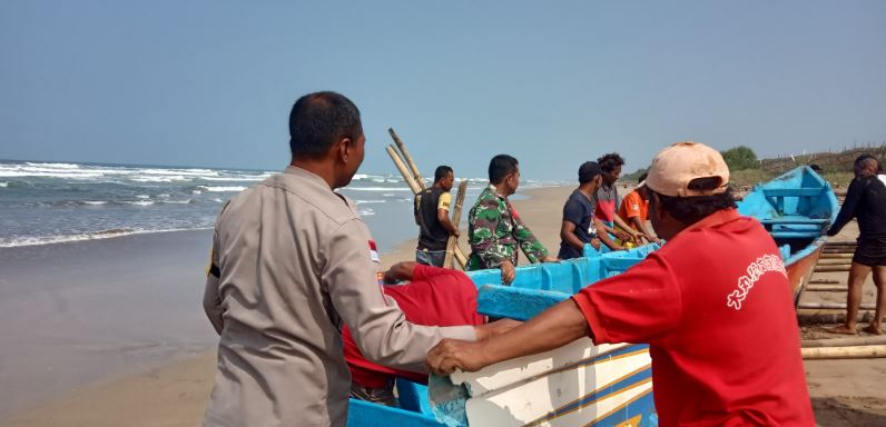 Bhabinkamtibmas Polsek Cikeusik Bantu Evakuasi Perahu Nelayan Binuangen yang Terdampar di Pesisir Pantai Kp Talanca 7 pc